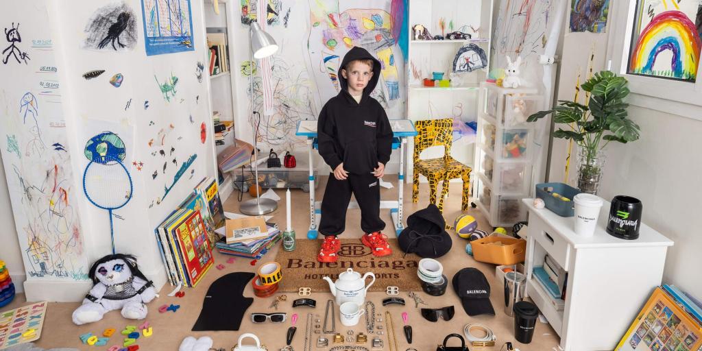 A young boy is pictured in a play room with a teddy bear in bondage style gear on the Balenciaga website.