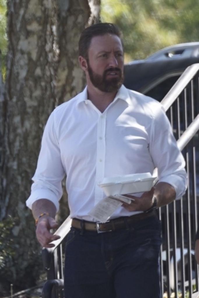 bearded kroy biermann holding a container of food